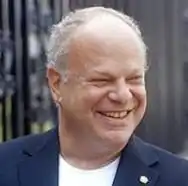 A cartoon centipede reads books and types on a laptop.